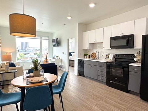 A modern kitchen with a dining table set for two.