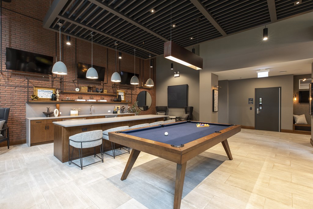 a games room with a pool table and a bar