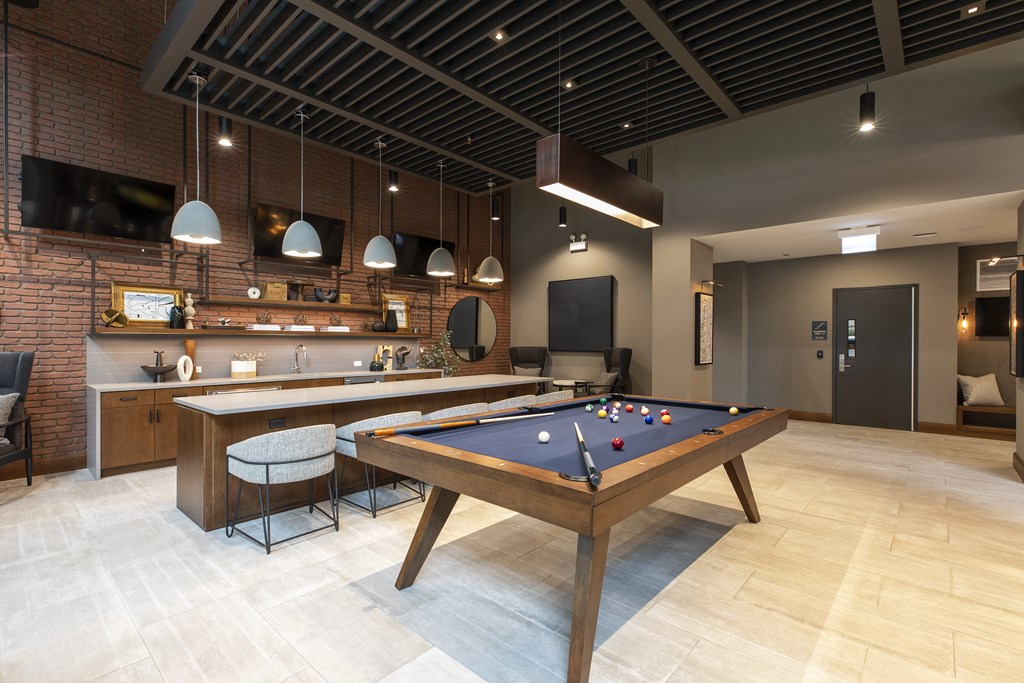 a games room with a pool table and a bar