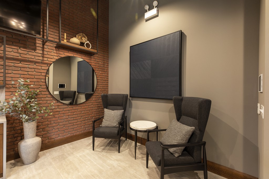 a living room with two chairs and a tv on the wall