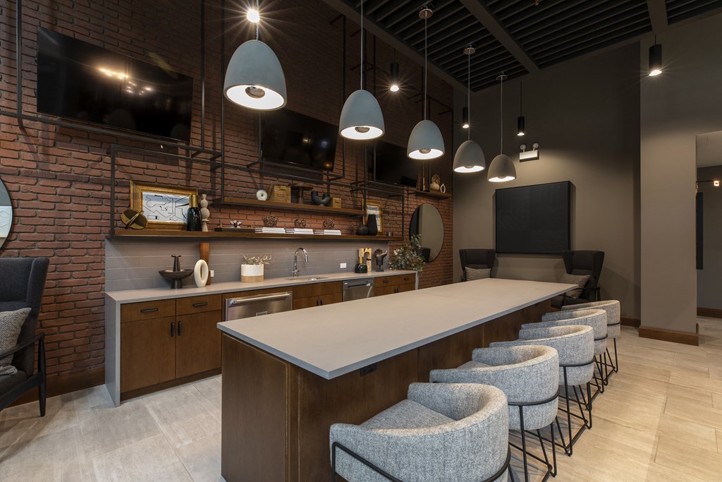 a communal table and chairs in a restaurant with exposed brick walls