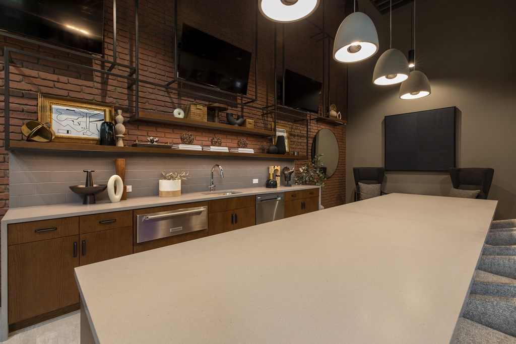 a kitchen with a large white counter top and a tv on the wall