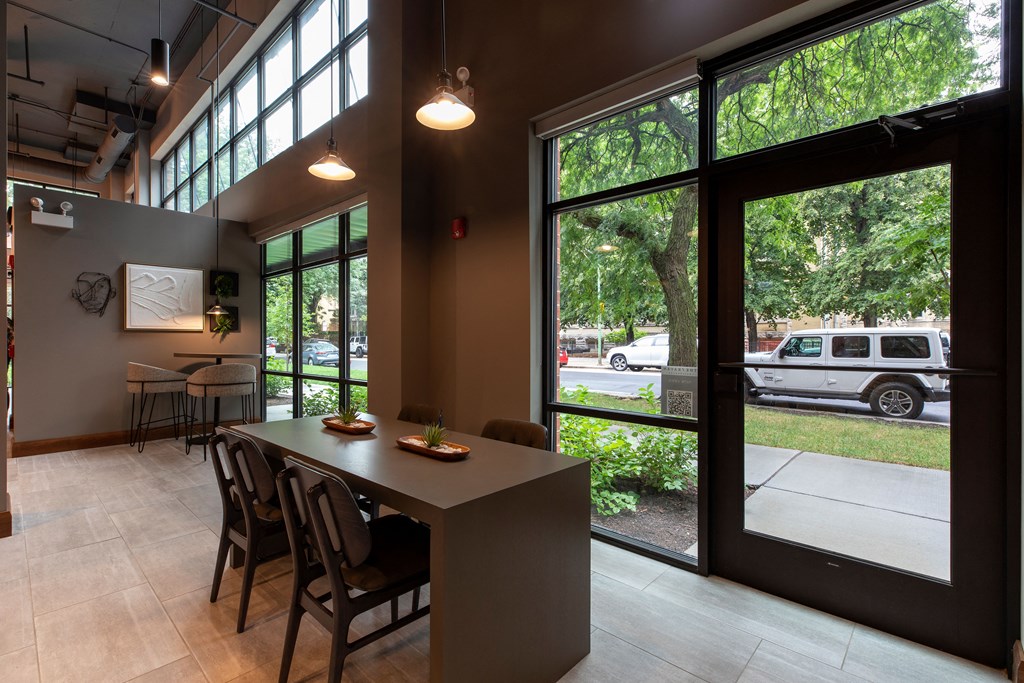 a dining room with large windows and a table with chairs