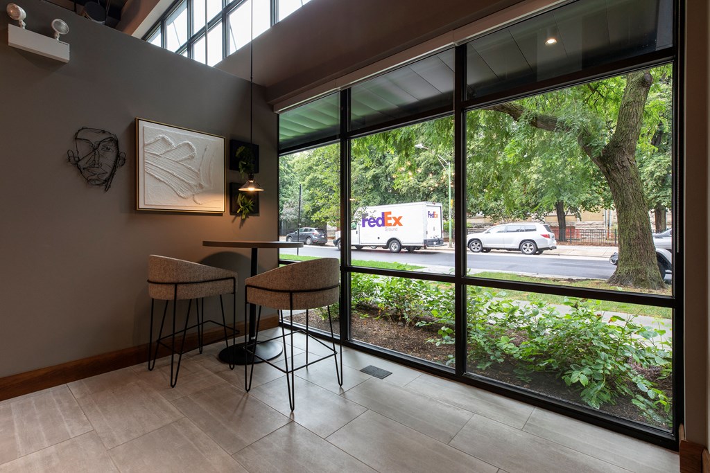 a bar with chairs and a table in front of a large window