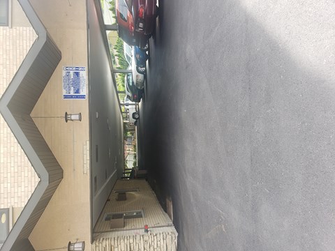 A narrow alley with a wall on one side and a metal gate on the other.
