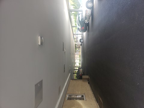 A long hallway with a black wall on the right and a white wall on the left.