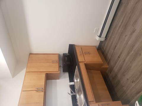 A kitchen with wooden cabinets and a black dishwasher.
