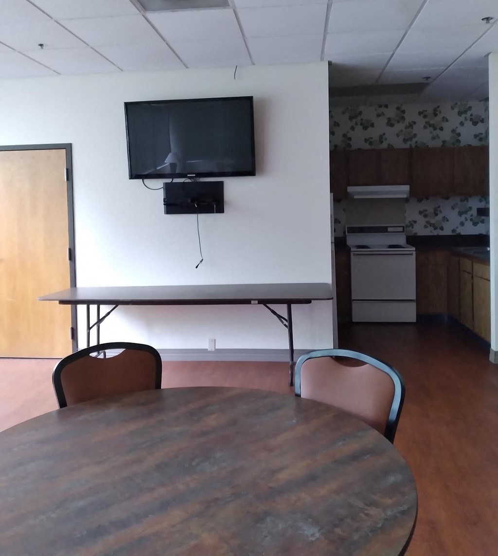 an empty conference room with a tv on the wall