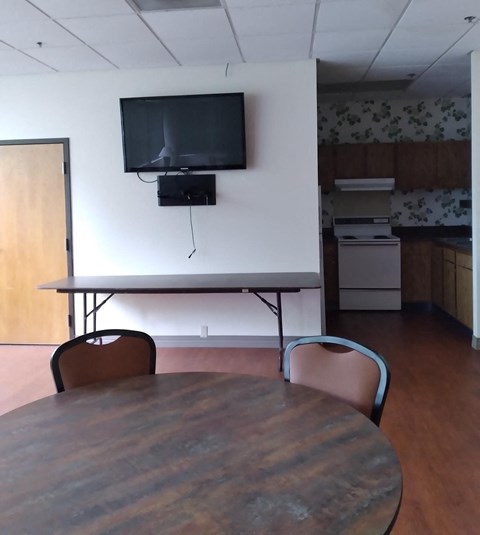 an empty conference room with a tv on the wall