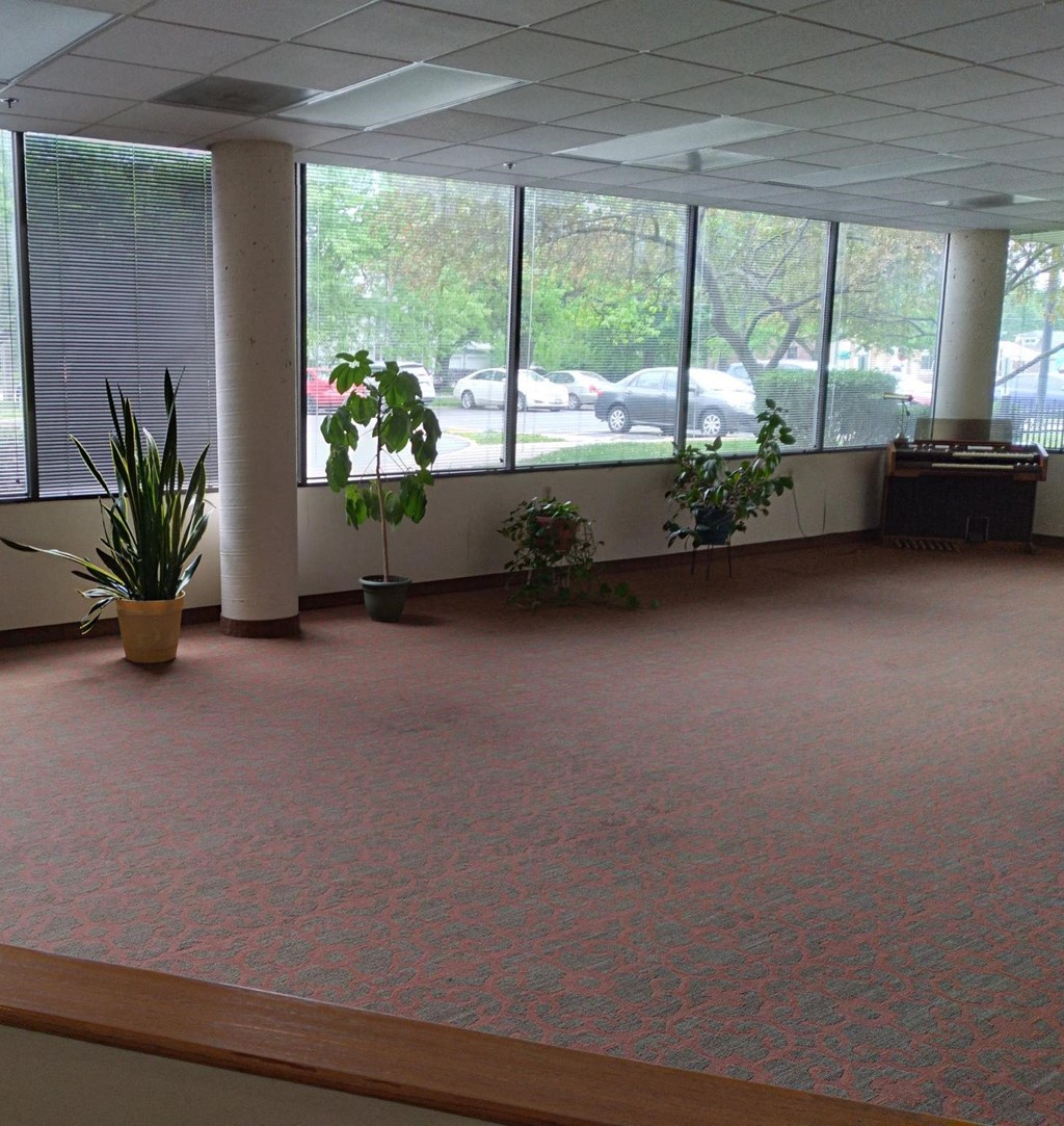 an empty room with plants and a desk