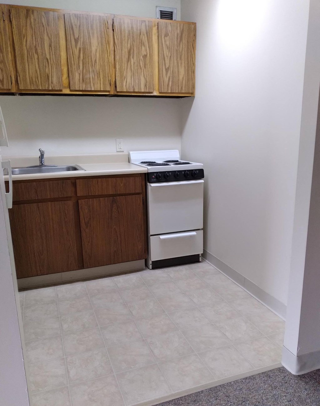 a kitchen with a stove top oven next to a sink