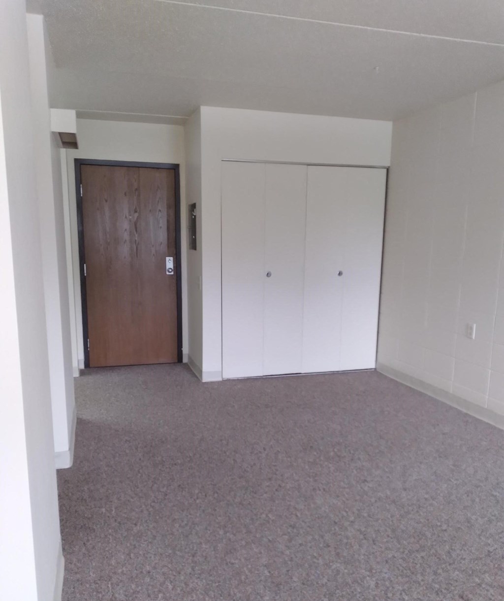an empty room with white walls and carpet