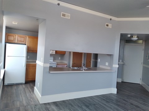 a kitchen and living room with a refrigerator and a sink