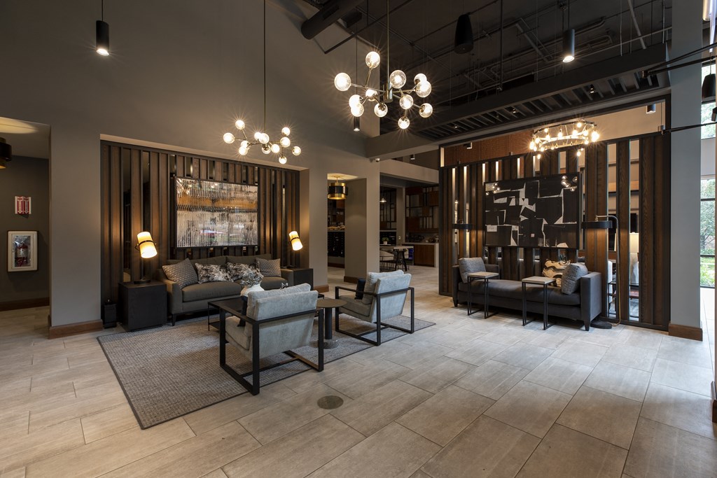 a lobby with couches chairs and tables and lights