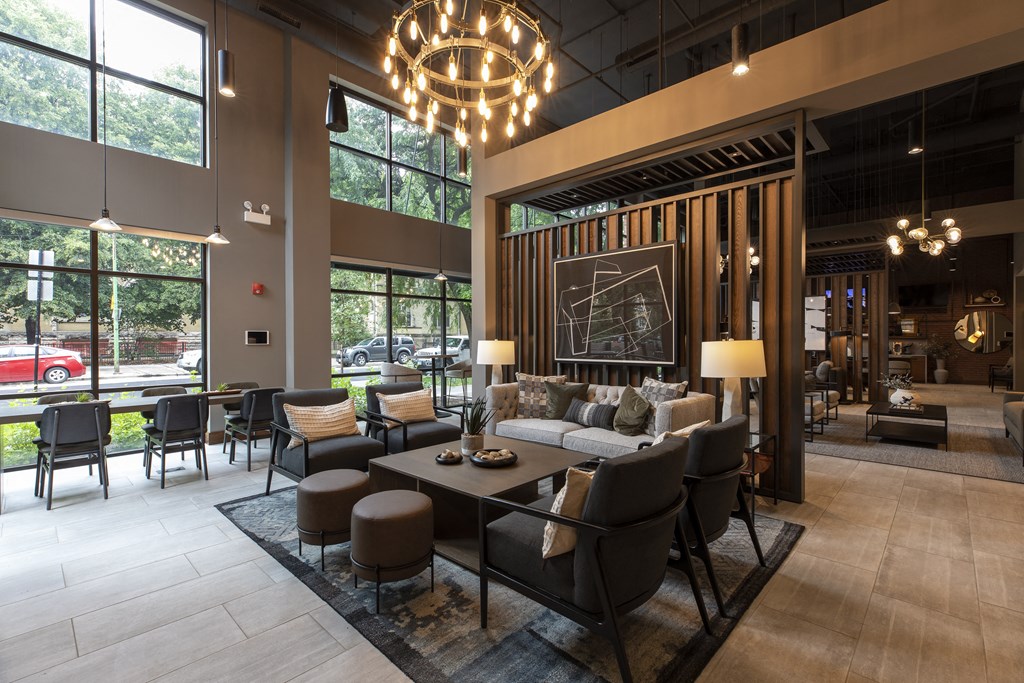 the lobby of a hotel with a large living room and dining area