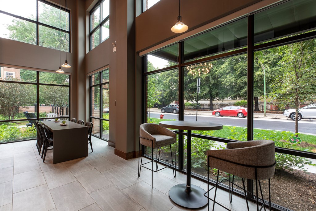 a lobby with tables and chairs and large windows
