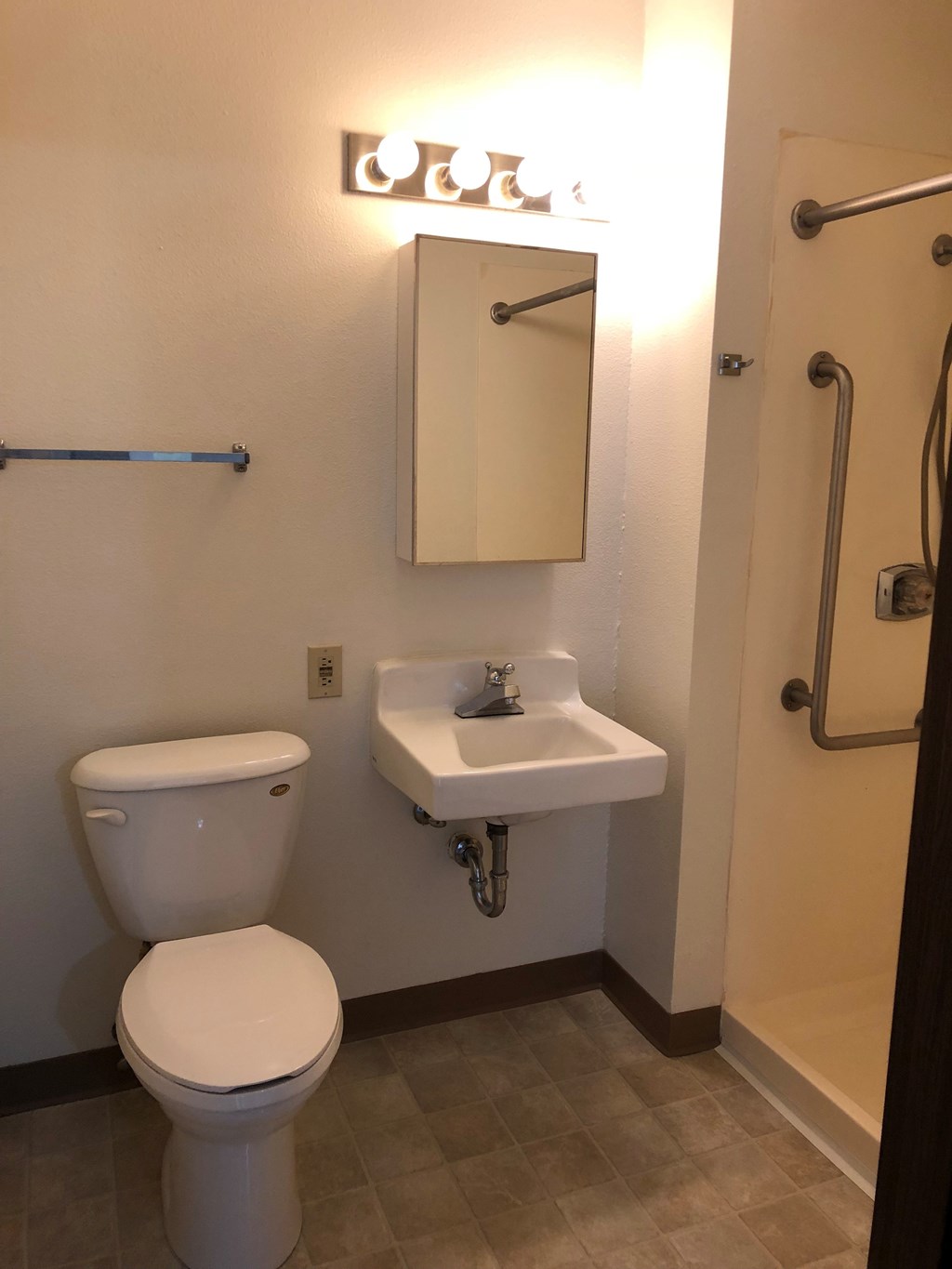 A white toilet sits next to a sink in a small bathroom.
