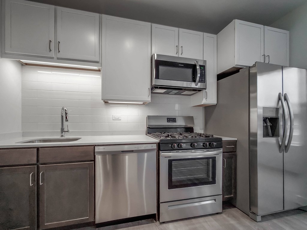 a kitchen with stainless steel appliances and white cabinets