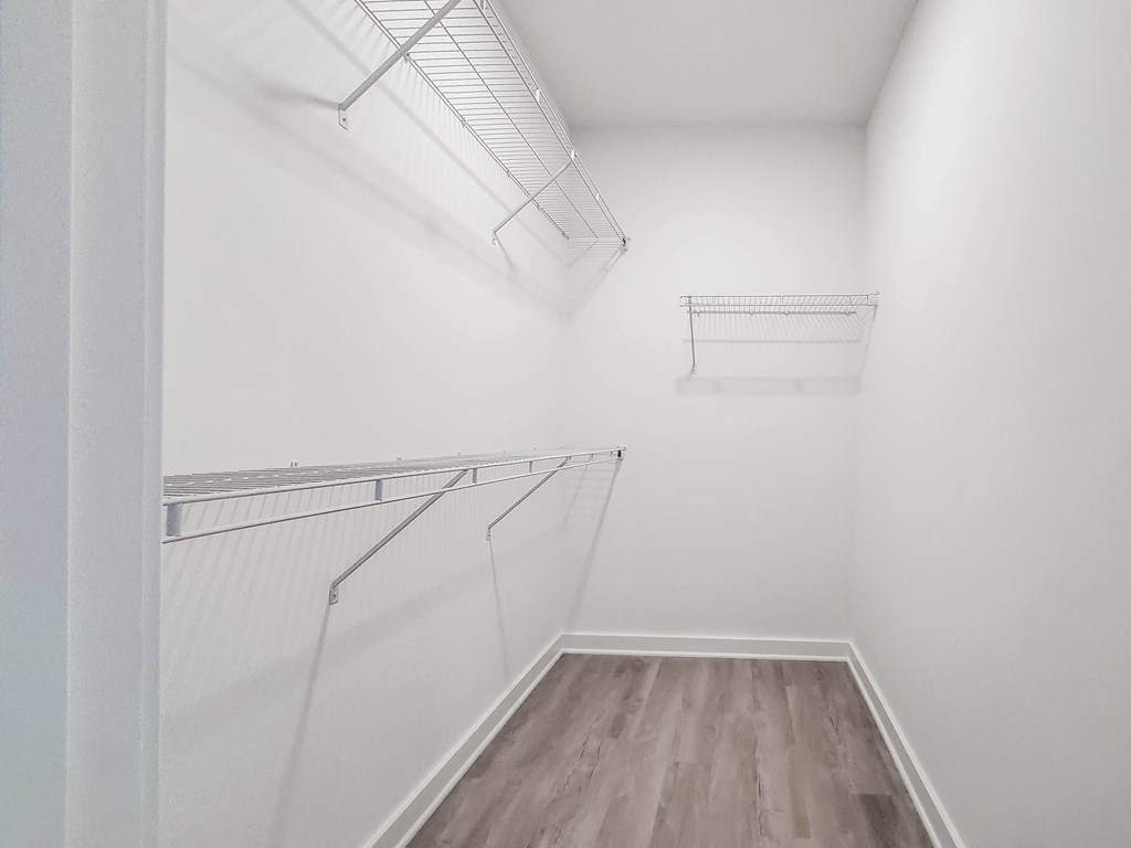our spacious closet is equipped with a mirrored wall and shelves