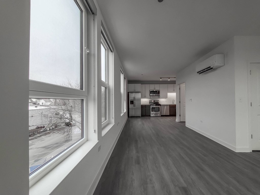 a living room with a large window and a kitchen