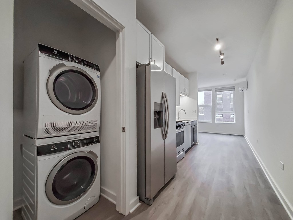 a washer and dryer in a laundry room with white cabinets