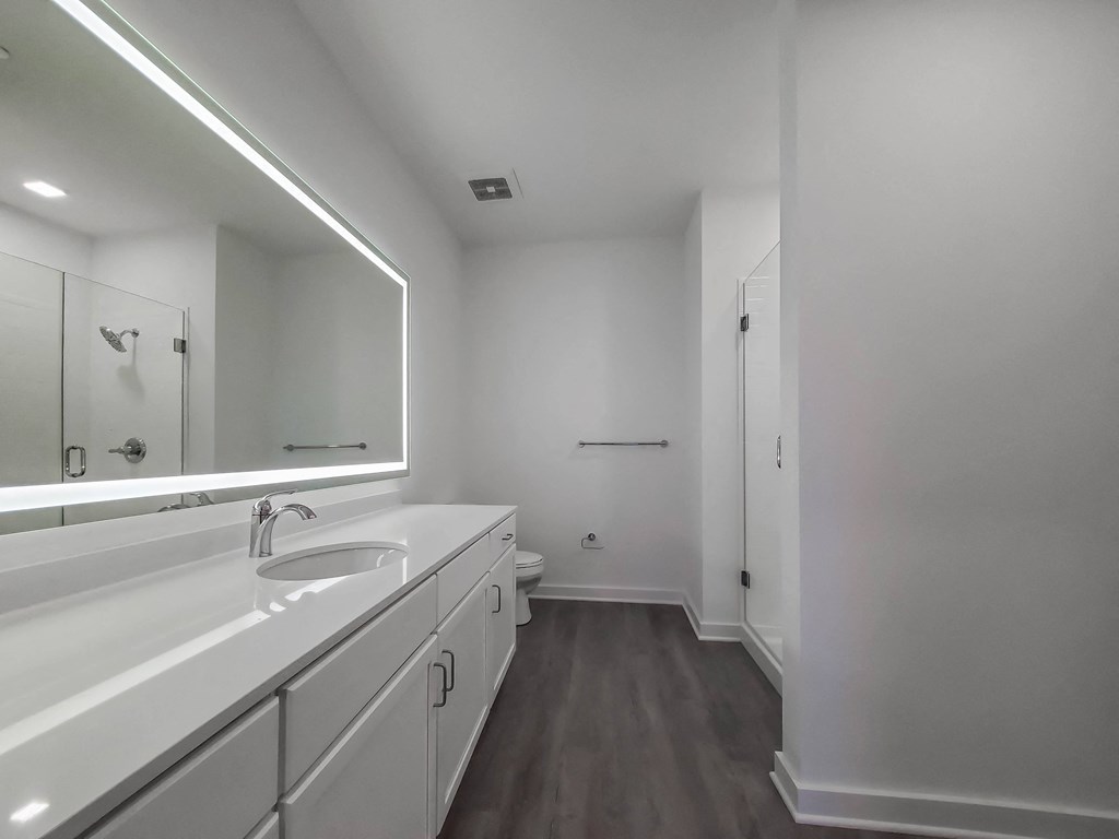 a bathroom with white cabinets and a sink and a mirror