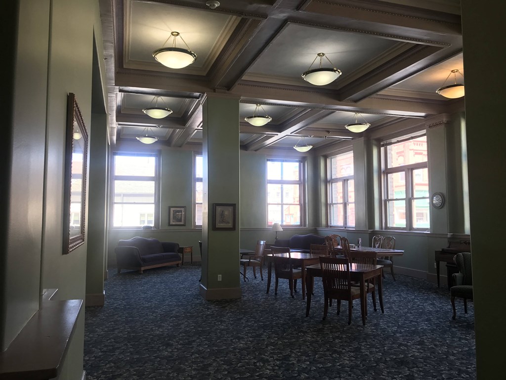 a large room with a row of windows and tables and chairs
