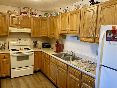 A kitchen with wooden cabinets and a white refrigerator.