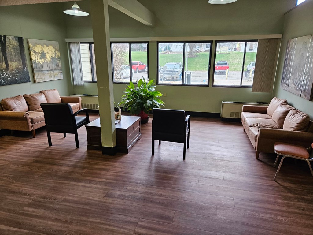 A living room with brown floors and furniture.