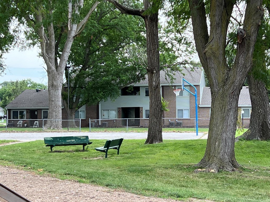 a park bench sitting in the grass near some trees