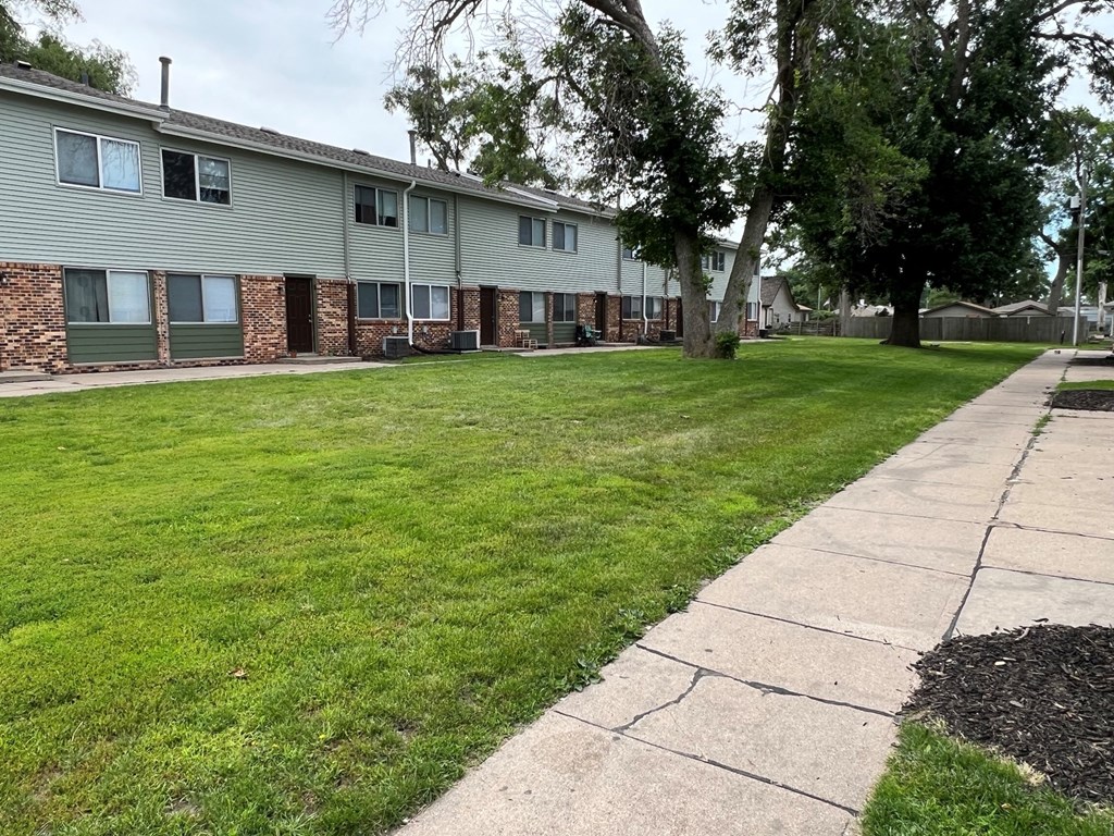 an apartment building with a sidewalk in front of it