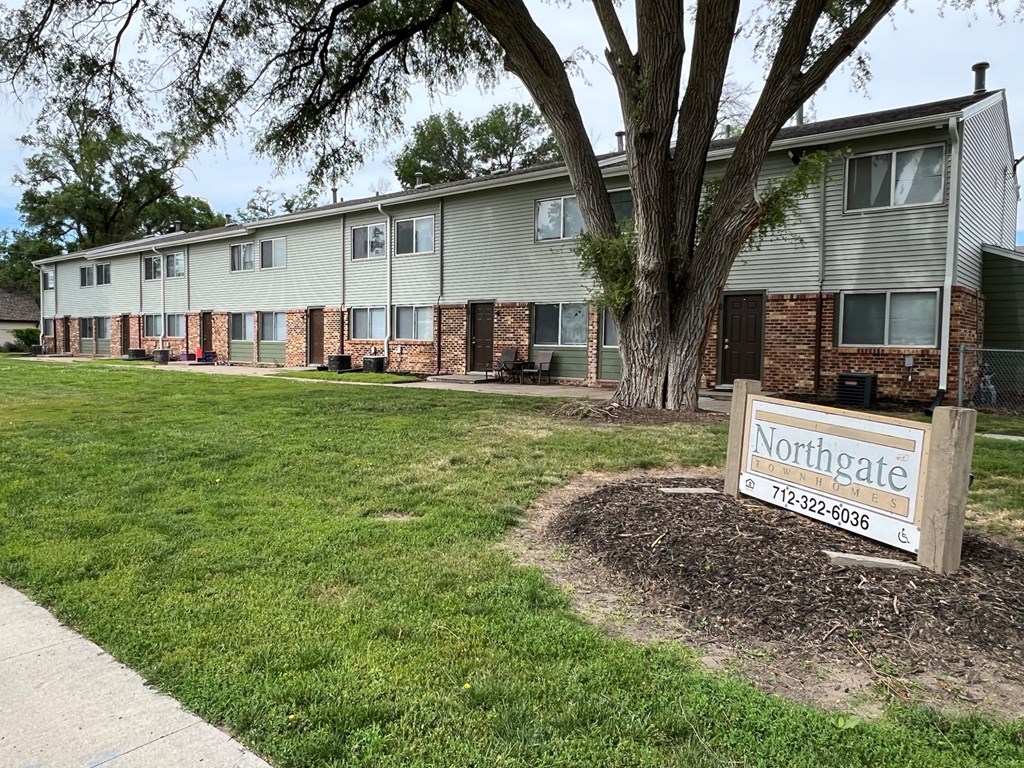 a neighborhood sign in front of an apartment building
