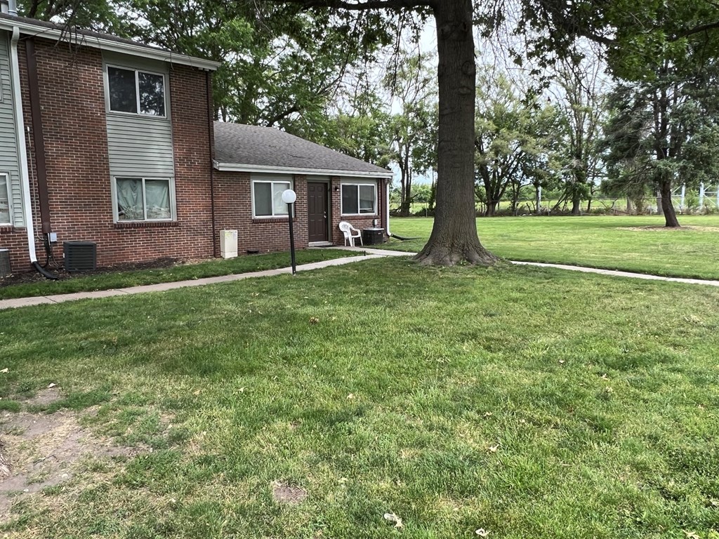 a house with a yard and a tree in front of it