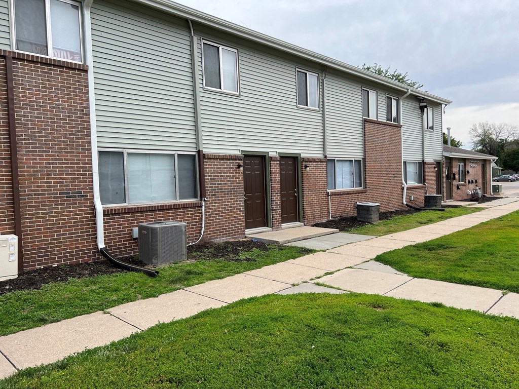 a brick building with a sidewalk in front of it