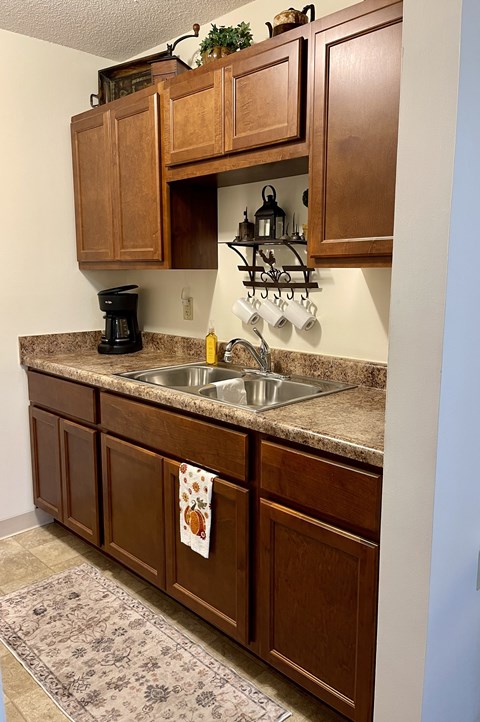 A kitchen with brown cabinets and a marble countertop.