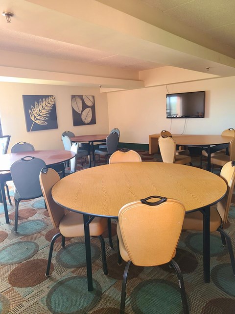 a dining room with tables and chairs and a television
