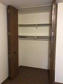 A brown closet with a white interior is open.