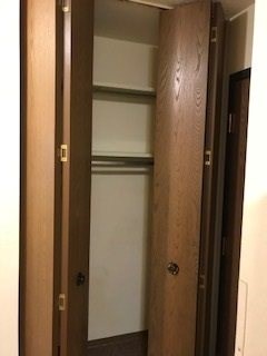 A brown door with a silver handle is open.