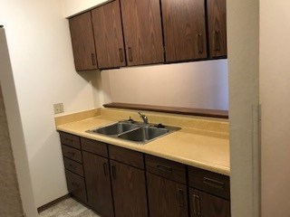 A kitchen with brown cabinets and a sink.