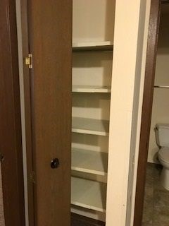 A brown door with a glass panel and a black knob.