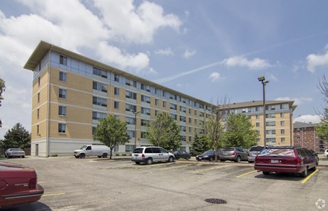 A parking lot with cars and a building in the background.