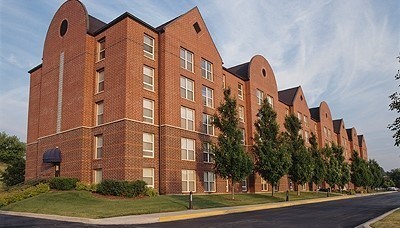 A long brick building with trees in front.