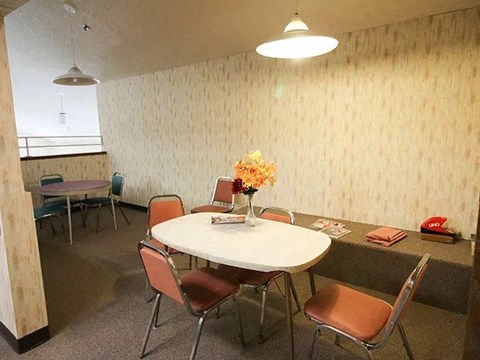 A conference room with a round table and chairs.