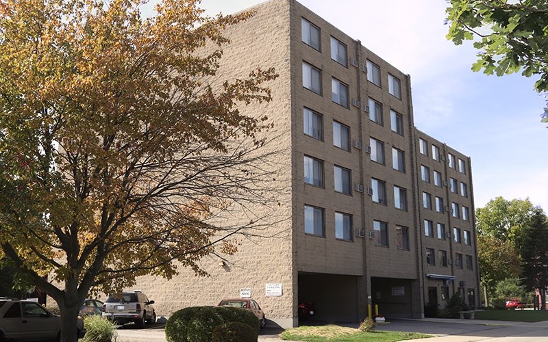 A large building with a parking lot in front.