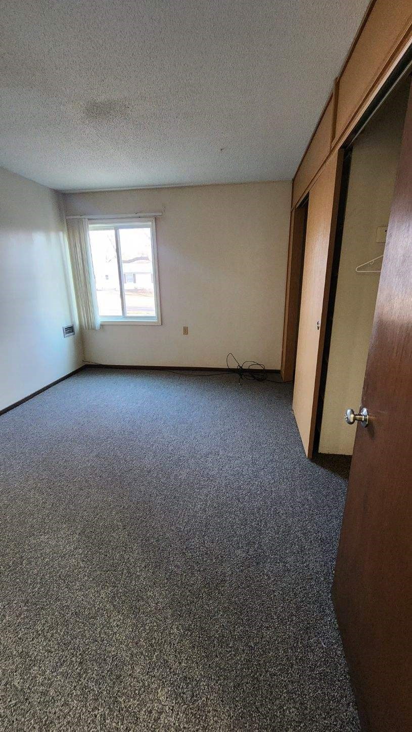an empty room with a window and a door