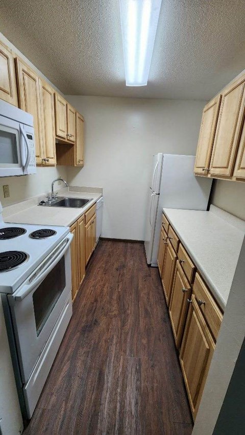 A kitchen with wooden cabinets and a white refrigerator.