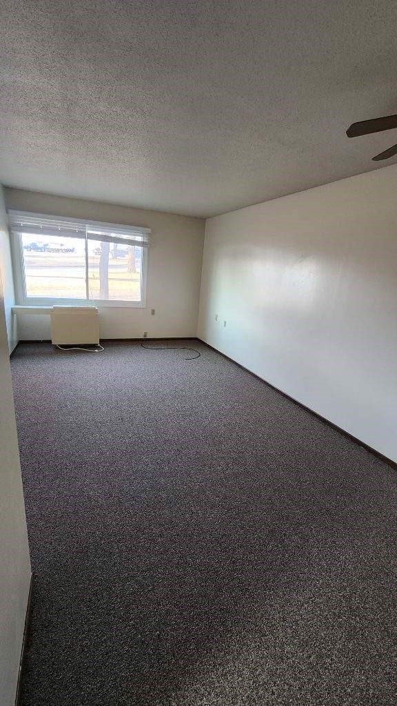 an empty room with a window and a chair