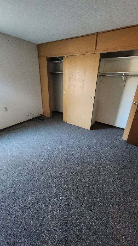 an empty room with a closet and a door open