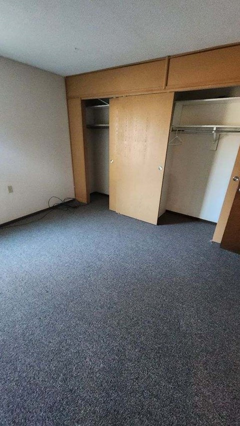 an empty room with a closet and a door open