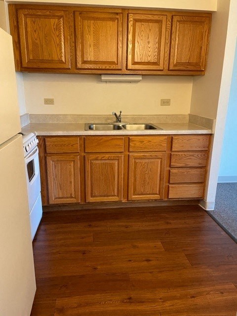 A kitchen with wooden cabinets and a white refrigerator.